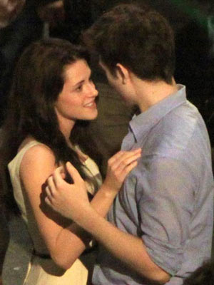 NEW VIDEO Robert Pattinson gives Kristen Stewart a passionate kiss when he thinks no-one's looking