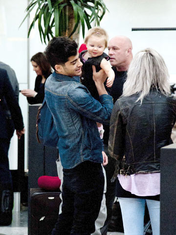 One Direction head back to US from London's Heathrow - with a baby in tow