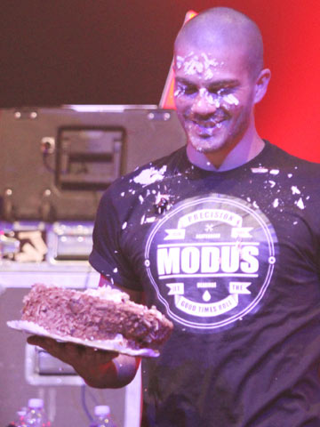 FUNNY PICTURE The Wanted throw Max George's birthday cake in his face in front of fans at gig