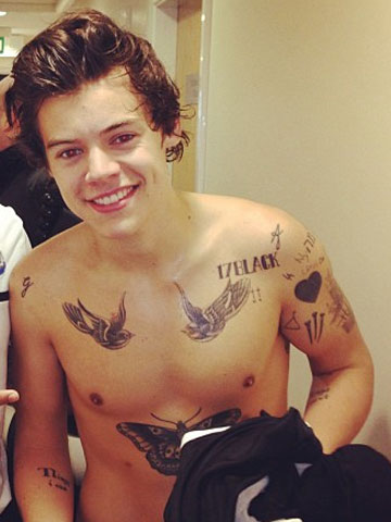 Cute! Topless One Direction star Harry Styles shows off tattoos as he cuddles baby Lux in Barcelona